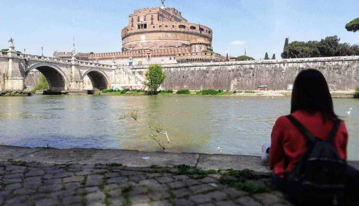 Castel Sant'Angelo e il Tevere a Roma, vista panoramica, turista seduta sul lungotevere, monumento storico e attrazione turistica, architettura romana, viaggio culturale.