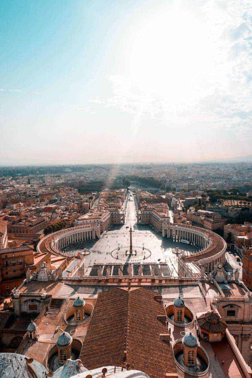 Cosa vedere a roma gratis: Roma, vista panoramica di San Pietro e piazza con colonnato, simbolo di città eterna, durante una giornata soleggiata in Italia.