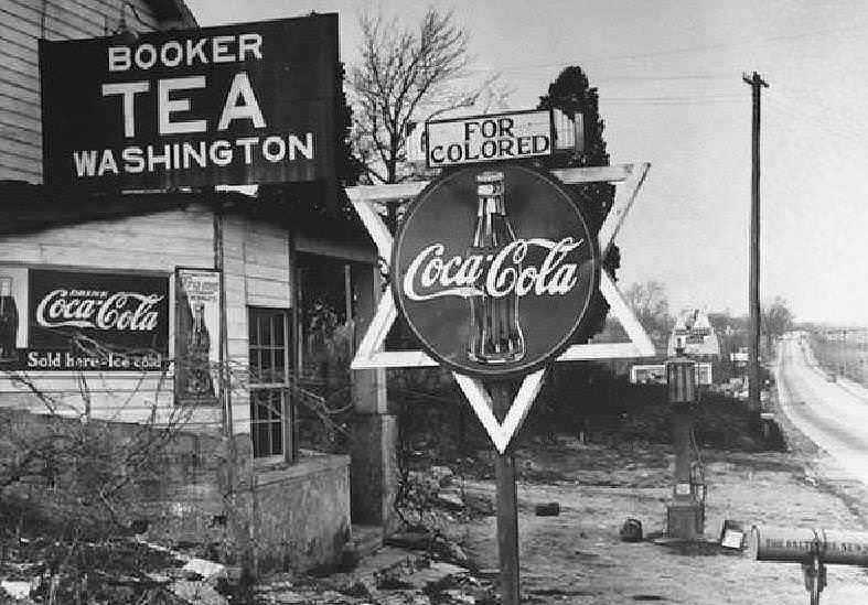 Coca Cola vantaggi e svantaggi 4 poco noti 2 Bottiglia di Coca-Cola vintage e insegne pubblicitarie in una strada storica americana senza colore.