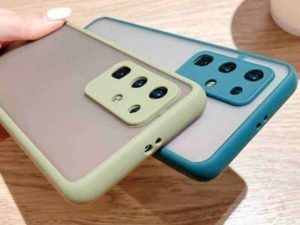 Fotocamera di smartphone con cover colorate su tavolo di legno, focus su moderni dispositivi mobili.