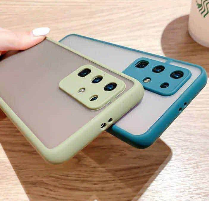 Fotocamera di smartphone con cover colorate su tavolo di legno, focus su moderni dispositivi mobili.