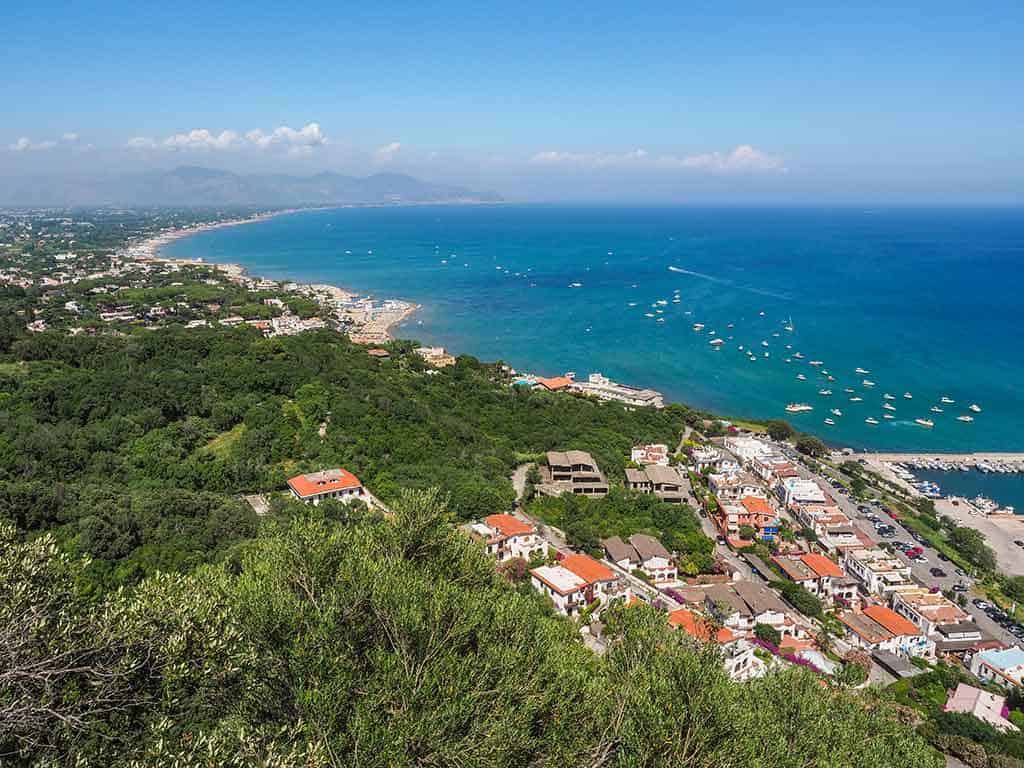 Vista panoramica della costa con mare azzurro, spiagge, insediamenti e verdeggianti colline, perfetta per appunti di viaggio o blog di turismo costiero e natura.