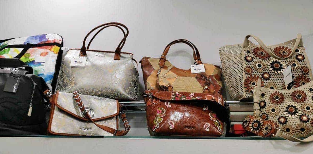 Borse da donna in vari modelli e design esposte su una scaffalatura, perfette per abbigliamento casual ed elegante. Ideali per aggiungere stile e praticità al look quotidiano.