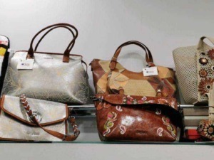 Borse da donna in vari modelli e design esposte su una scaffalatura, perfette per abbigliamento casual ed elegante. Ideali per aggiungere stile e praticità al look quotidiano.