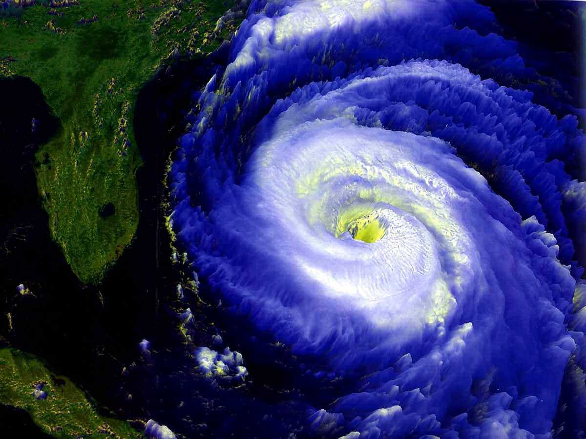 Nube temporale ciclonica con vortice preciso e dettagliato, vista dall'alto, con tonalità intense di blu, bianco e giallo, rappresenta fenomeni meteorologici estremi.