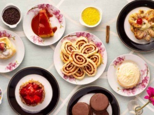 Deliziosi dolci e dessert italiani su piatti floreali, tra torte, cioccolatini e biscotti, perfetti per ogni occasione di festa e dolcezza.