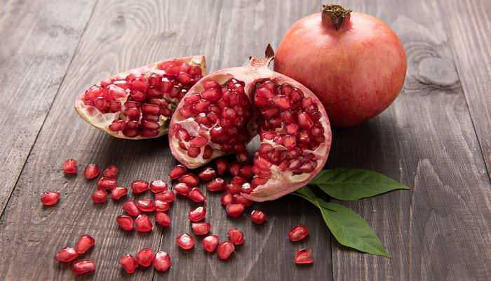 Cachi e melograno freschi su superficie di legno, frutta naturale e salutare per uno stile di vita sano. Alimenti ricchi di vitamine e antiossidanti benefiche per il corpo. Un'immagine di cachi e melograno freschi con foglie verdi su superficie di legno, evidenziando frutta naturale, salutare e ricca di nutrienti. Ideale per contenuti su alimentazione sana, diete e benessere.