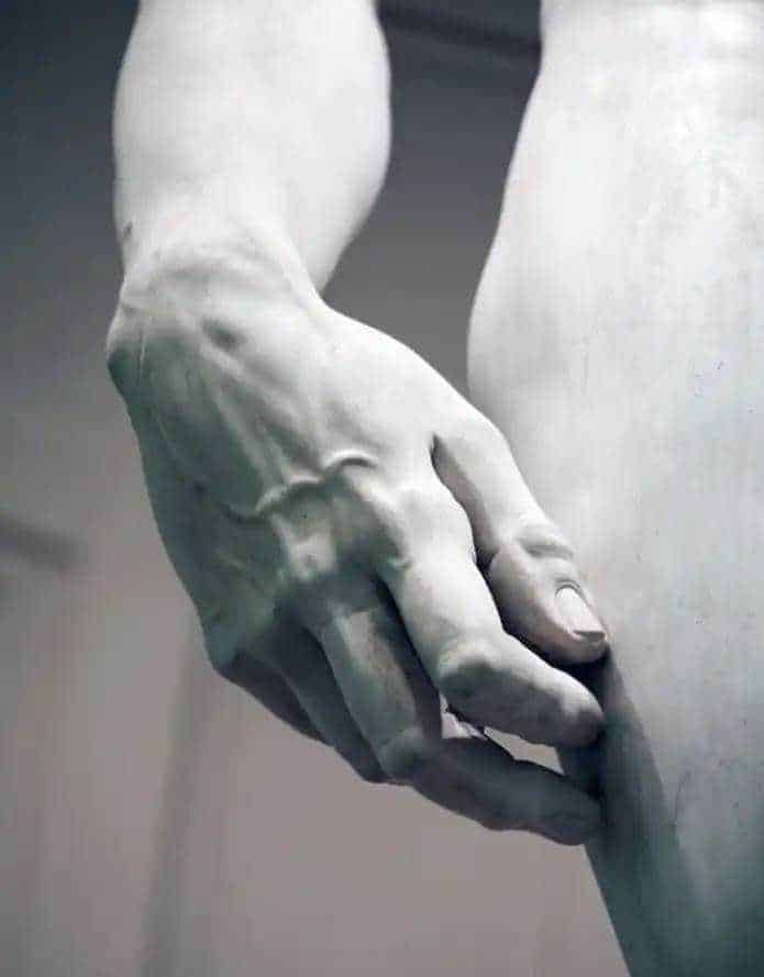 Stringa di testo alternativo (alt): Mano scolpita in marmo che tiene delicatamente un'armonia statica, simbolo di arte e cultura classica.
