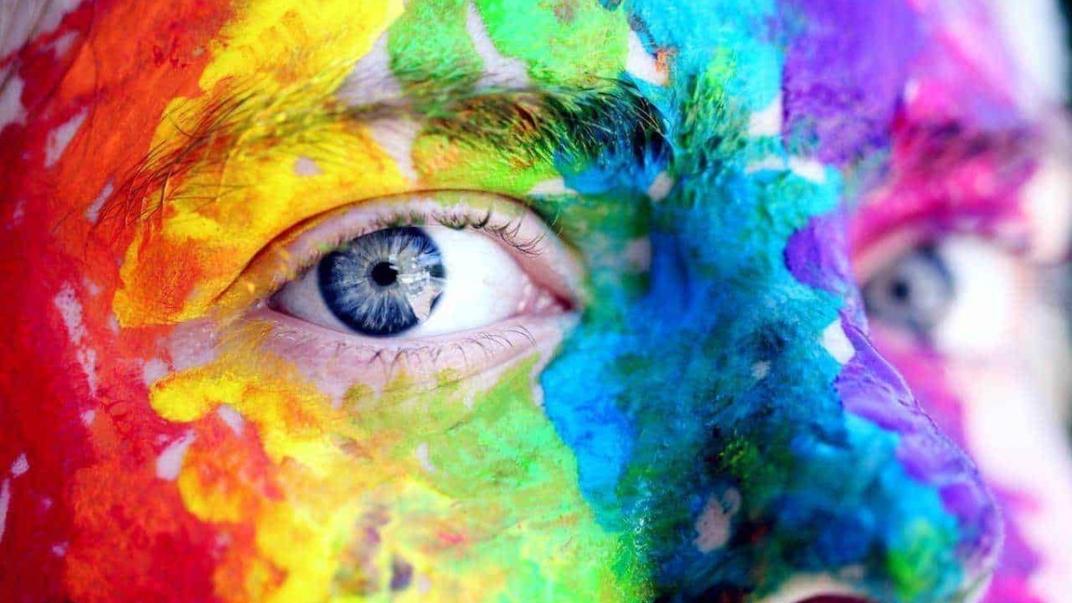 Pittura colorata sul volto con dettagli degli occhi, arte, creatività e espressione artistica, fotografia artistica, tecnica di body painting.
