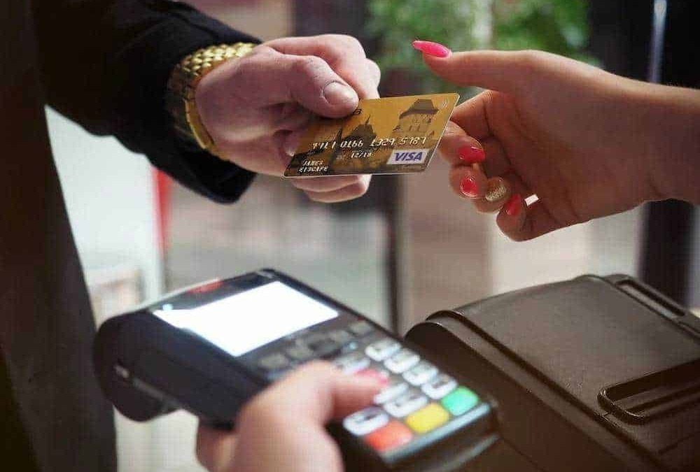 Pagamento contactless con carta di credito presso punto vendita. Tecnologia moderna per transazioni rapide e sicure, senza contatto tra cliente e cassiere.