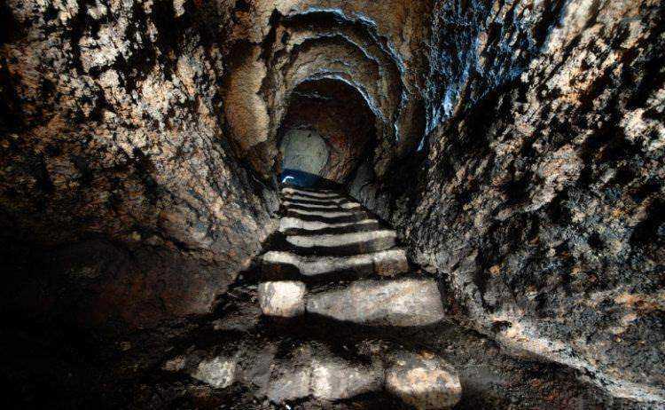 Scorci di una grotta sotterranea con gradini di pietra, ambiente naturale e misterioso, ideale per esplorazioni e avventure speleologiche in Italia.