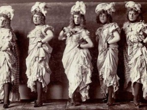 Donne in abiti d'epoca, con eleganti cappelli e vestiti sfarzosi, in posa per uno scatto vintage, che rappresenta moda, storia e cultura dell'epoca.
