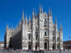 Cattedrale di Milano, famoso esempio di architettura gotica in Italia, con dettagli elaborati e imponente facciata in marmo bianco sotto un cielo blu.