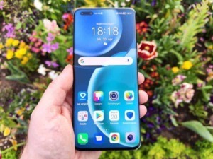 Smartphone Android con schermo accesso, in mano, tra fiori colorati, esempio di tecnologia e smartphone latest generation, in contesto naturale e moderno.