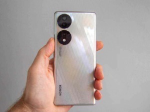Telefono Honor con telecamere posteriori a doppio obiettivo, design elegante e riflettente, in mano a una persona. Perfetto per recensioni di smartphone e tecnologia moderna.