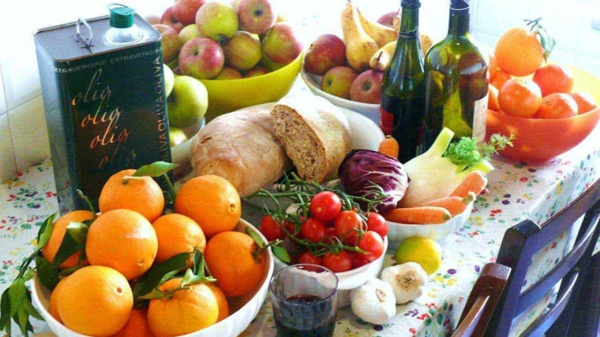Tavola con frutta, verdura, pane, olio e vino della dieta mediterranea