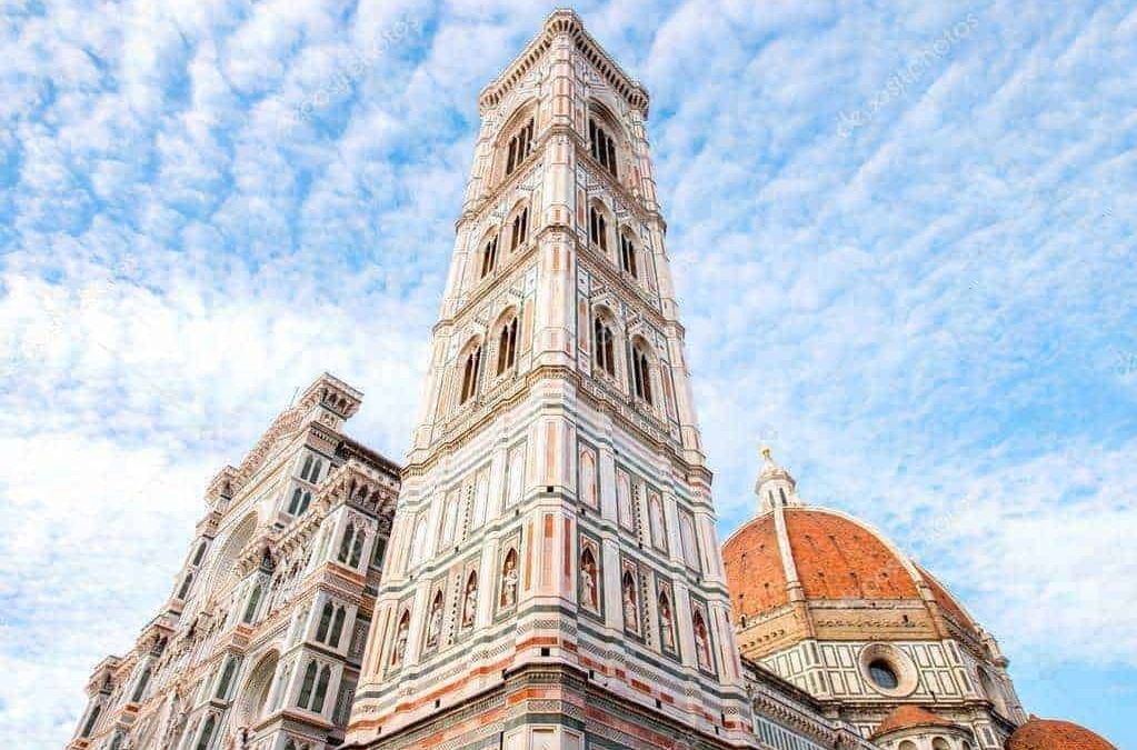 Torri di Firenze, panorama del campanile di Giotto e della Cattedrale di Santa Maria del Fiore con cielo azzurro e nuvole.
