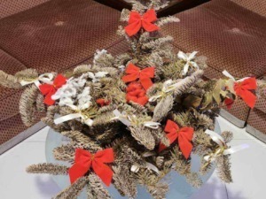 Fiore di Natale decorato con bacche rosse, nastri bianchi e fiocchi rossi, ideale come centro tavola natalizio, perfetto per decorare la casa durante le festività festive.
