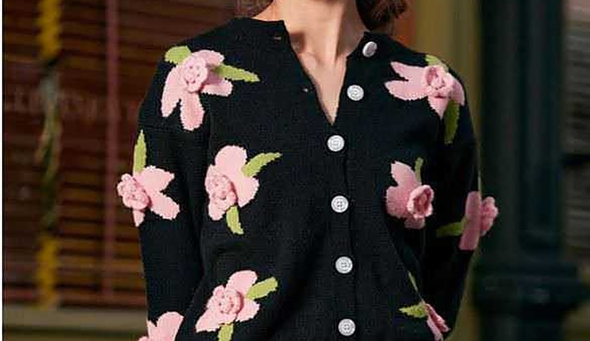 Femminile donna con maglione nero a fiori rosa e verde
