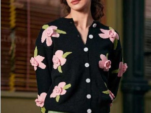 Femminile donna con maglione nero a fiori rosa e verde, ambiente elegante, moda autunnale, fashion blogger.