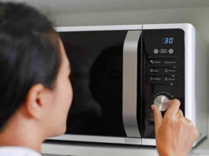 Microonde in funzione in cucina, utilizzo programmi di cottura rapida e controllo digitale, elettrodomestico essenziale per preparare pasti veloci.