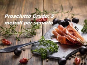 Prosciutto crudo in stile rustico con erbe aromatiche e olive nere su un tagliere di legno, perfetto per antipasti e aperitivi, un classico della cucina italiana.