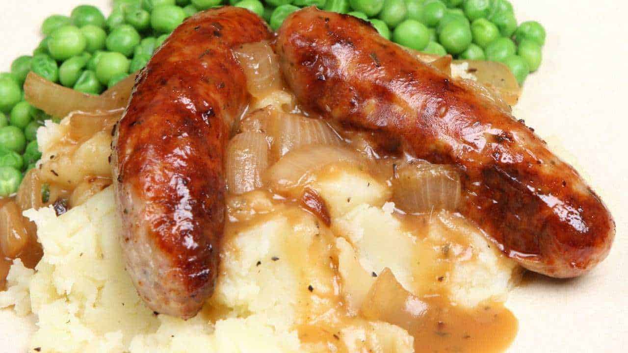 Cucina inglese, i 5 piatti che devi mangiare se vai a Londra 6 Salsiccia alla griglia con purè di patate e piselli freschi, piatto tradizionale italiano, ricco di sapori autentici.