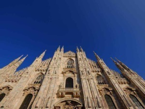 Majestosa cattedrale gotica con guglie alte e dettagli architettonici intricati contro cielo azzurro limpido.
