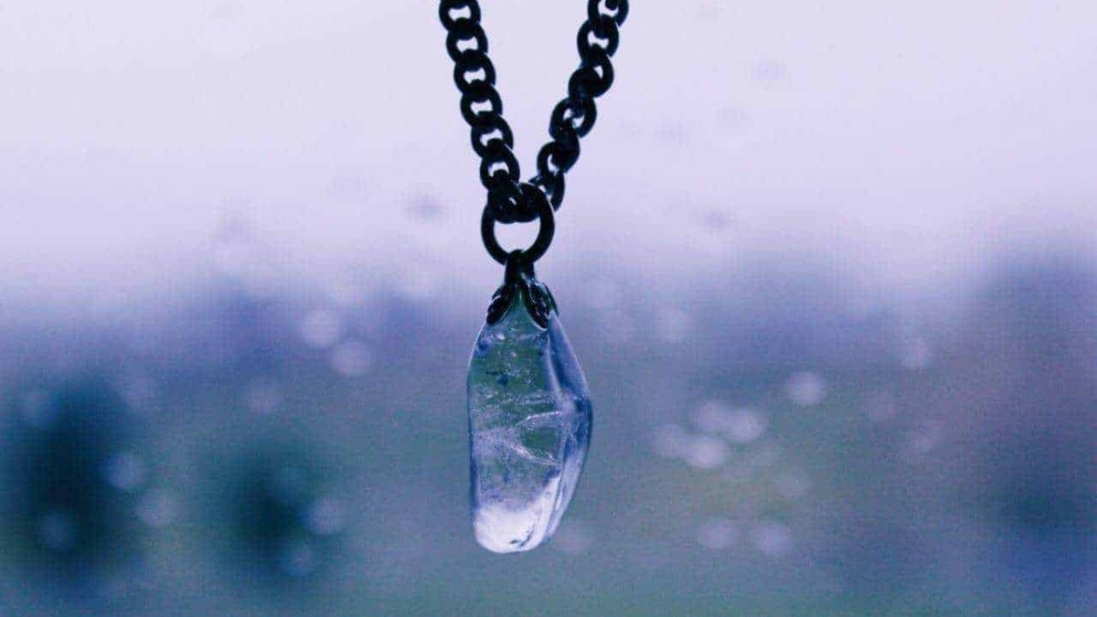 Cerniera con pendente di cristallo trasparente su una catena in metallo, dettaglio di gioielli eleganti e raffinati.
