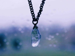 Cerniera con pendente di cristallo trasparente su una catena in metallo, dettaglio di gioielli eleganti e raffinati.