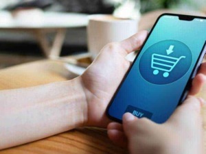 Acquisto online tramite smartphone con icona carrello della spesa digitale.