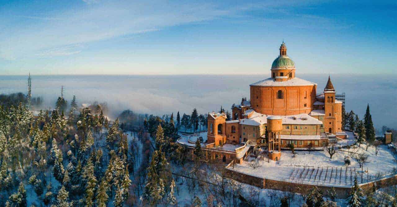 Castello di neve in inverno con paesaggio montano e cielo azzurro, vista panoramica sulla natura e sull'architettura storica, atmosfera tranquilla e suggestiva, destinazione ideale per fotografie e viaggi.
