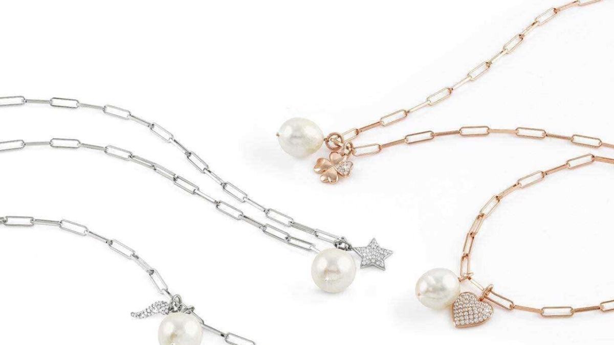 Collane con perle e charms in argento e oro rosa su sfondo bianco elegante e minimalista, perfette per accessori moda femminili raffinati e di classe.