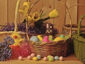 Uova di Pasqua colorate in un cestino con fiori primaverili e decorazioni pasquali, perfette per celebrare la festività primaverile e Pasqua, ideale per decorazioni festive e ricette pasquali.