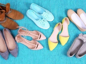 Sandali e scarpe in vari colori e stili disposte su un tappeto azzurro con texture. Scarpe cerimoniali, sportive e casual, ideali per diverse occasioni di moda e stile di vita.
