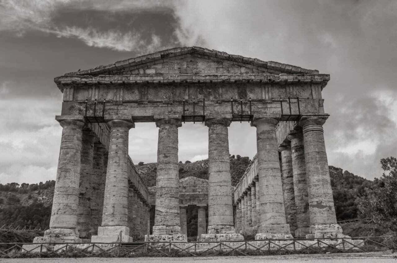 Antica struttura architettonica greca con colonne in pietra, patrimonio storico, sito archeologico, monumento culturale, richiama l'arte dell'antica Grecia e il suo fascino classico.