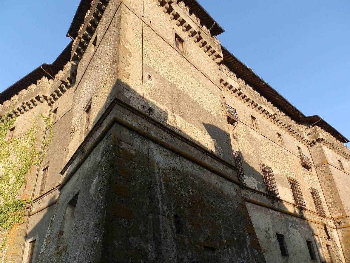 Vecchio castello medievale in pietra con torrette e merlature, esempio di architettura storica italiana, fotografato sotto un cielo limpido.