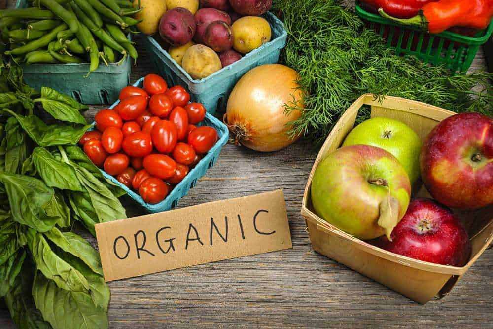 Pomodori e mele bio in cassette di legno organico, verdure fresche e salutari da agricoltura sostenibile. Prodotti biologici e naturali per uno stile di vita sano e consapevole.