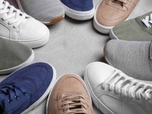 Scarpe da ginnastica colorate disposte in cerchio su sfondo grigio, moda casual, stile streetwear, calzature sportive per uomo e donna, tendenze calzature primavera estate.
