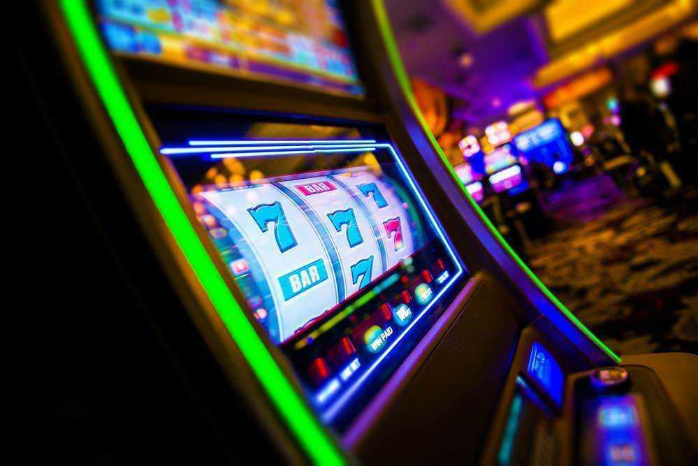 Slot machine con luci colorate in un casinò di sera, atmosfera vibrante e riconoscibile per appassionati di giochi d'azzardo.