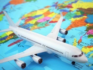 Aereo di plastica sopra una mappa del mondo colorata, simbolo di viaggi e avventure internazionali, con focus su destinazioni globali e cultura distintiva.