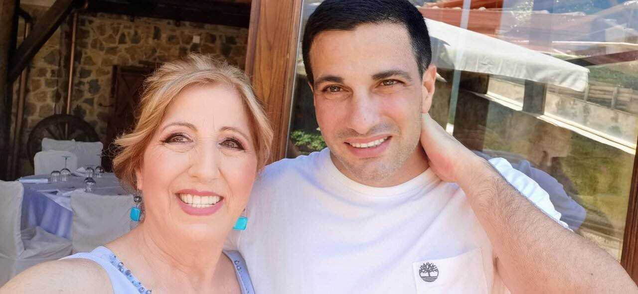 Sorriso felice tra mamma e figlio in un ristorante all'aperto con ambientazione rustica.