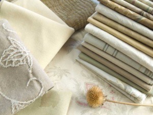 Morbide stoffe e tessuti decorativi in tonalità neutre e natura, perfetti per arredamento e home decor. Pieghe di tessuto eleganti e dettagli ricamati creano un'atmosfera accogliente.
