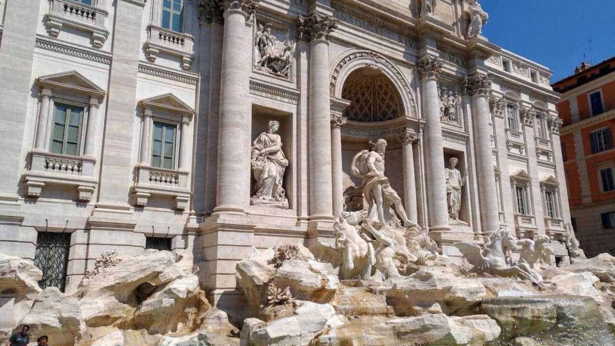 Fountain of the Trevi Palace, a famous Baroque masterpiece in Rome, featuring intricate sculptures and cascading water, popular tourist attraction and symbol of Italy.