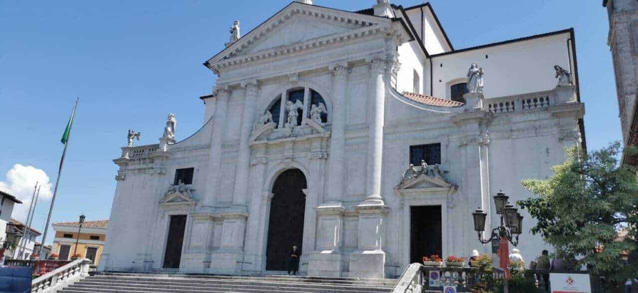 Maestosa chiesa barocca in marmo bianco con statue e dettagli artistici, esempio di architettura religiosa storica in Italia.