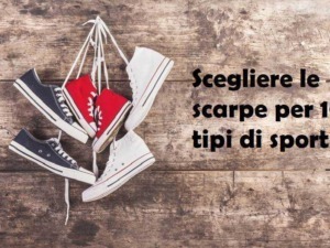 Scarpe sportive alternative di diversi stili e colori disposte su un tavolo di legno rustico.