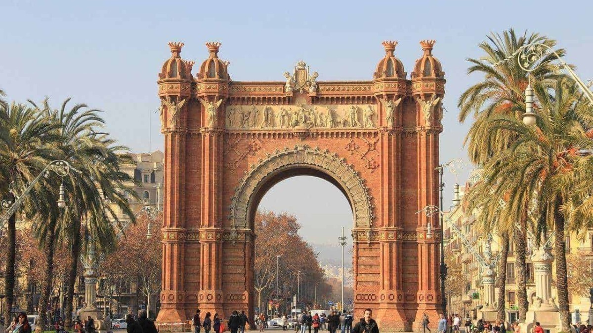 Arco di Trionfo di Marsiglia, monumento storico in stile architettonico veneziano, situato nel centro della città, circondato da palme e visitatori.