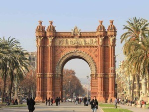 Arco di Trionfo di Marsiglia, monumento storico in stile architettonico veneziano, situato nel centro della città, circondato da palme e visitatori.
