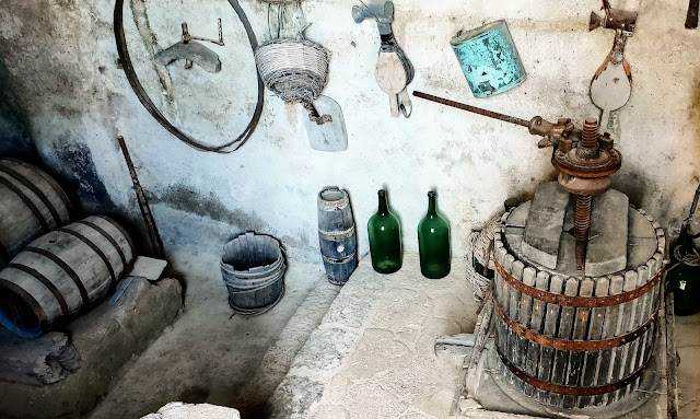 Vecchio torchio per la produzione di vino con bottiglie di vetro, Vinificazione a Ischia