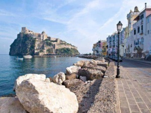 Ferrara di mare con Castello Aragonese e case colorate sul lungomare di Ischia, Italia, in cute con vista sul mare e il cielo blu, perfetta per blog di viaggi e turismo attraverso Appunti Sul Blog.